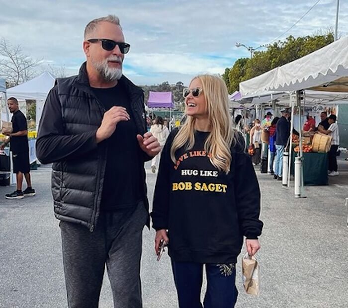 Candace Cameron Bure wearing a "Love Like Jesus, Hug Like Bob Saget" sweatshirt